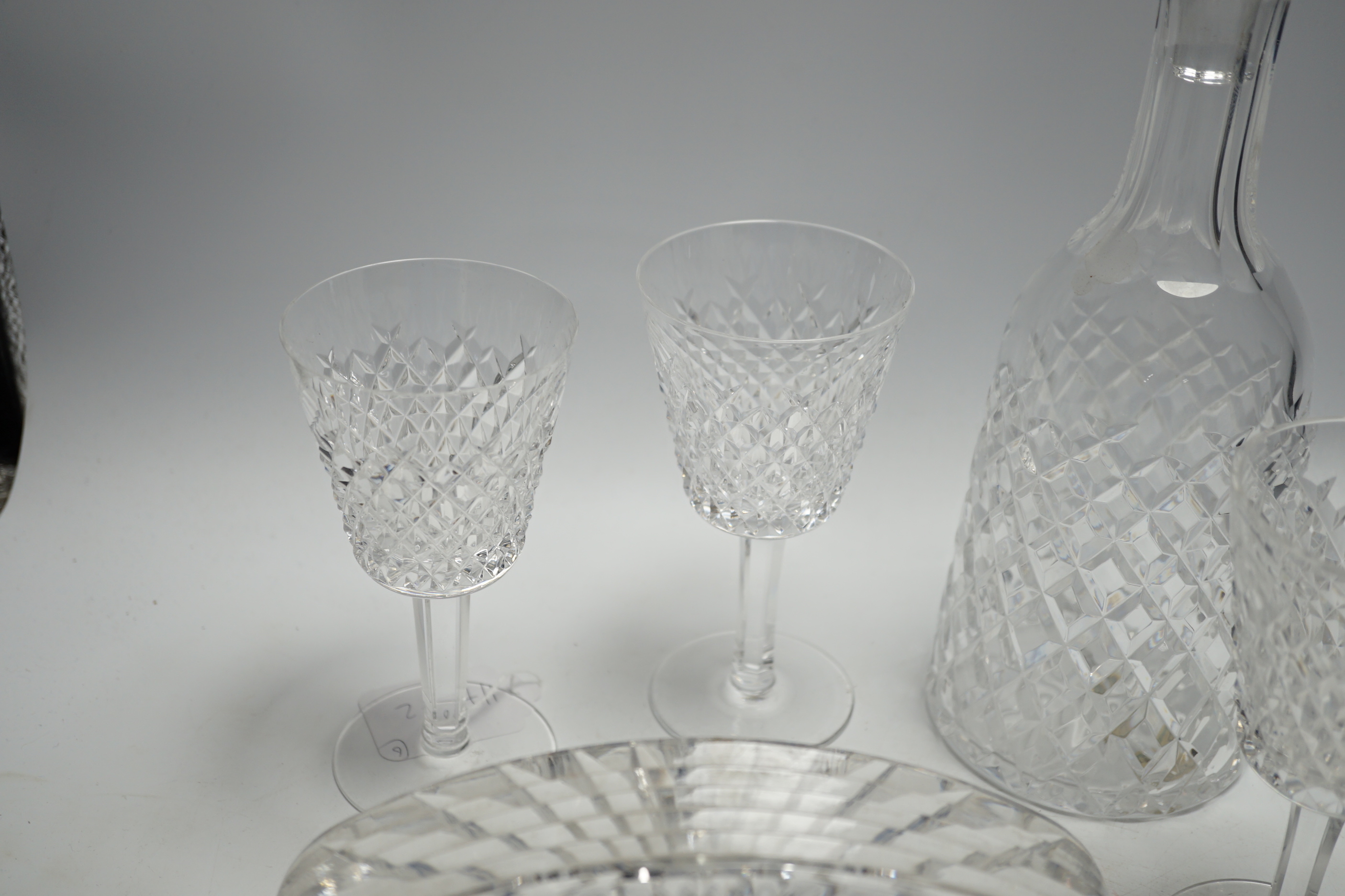 A Waterford cut glass decanter, four glasses and a timepiece